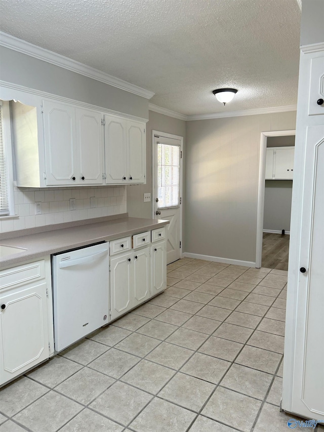 kitchen with white dishwasher, crown molding, decorative backsplash, and white cabinets