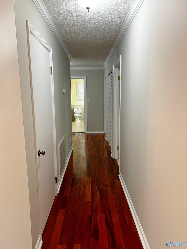 hall with dark hardwood / wood-style flooring, crown molding, and a textured ceiling