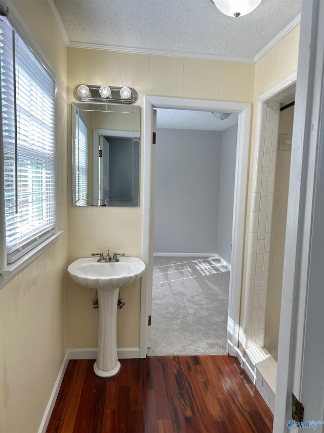 bathroom with ornamental molding, hardwood / wood-style floors, and a textured ceiling