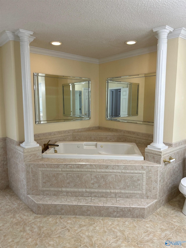 bathroom with ornate columns, ornamental molding, tiled bath, and a textured ceiling