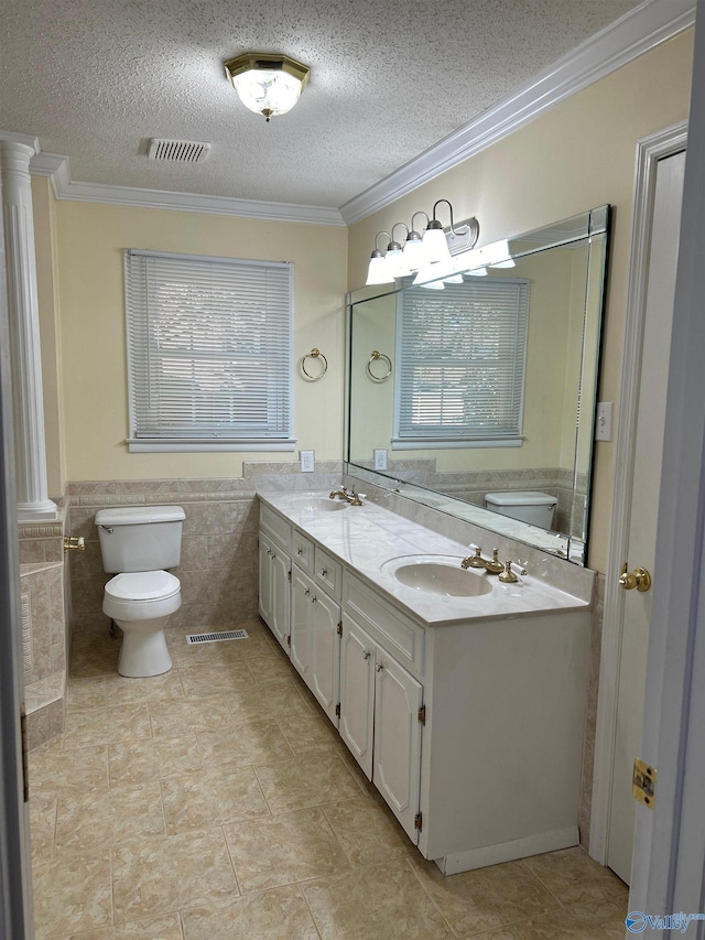 bathroom featuring crown molding, vanity, and a textured ceiling