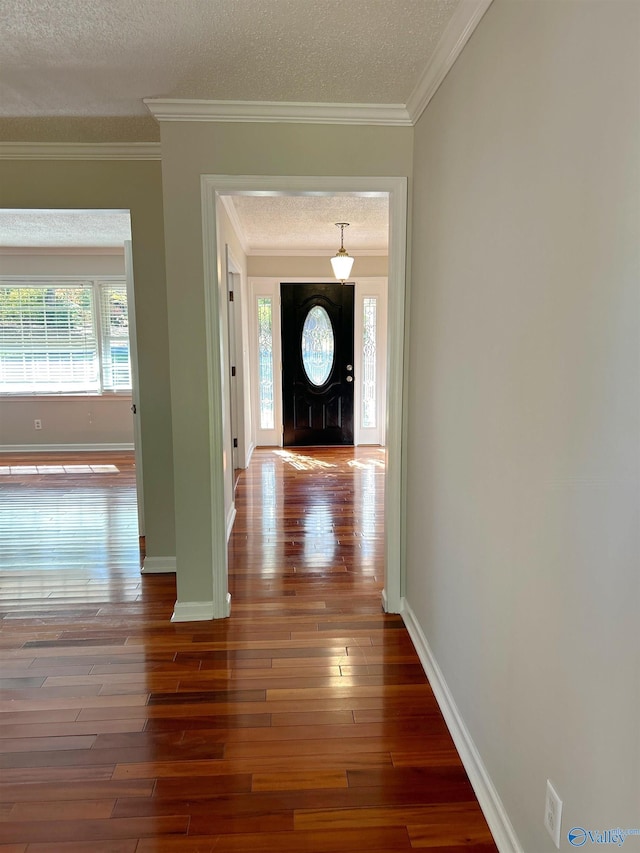 foyer featuring ornamental molding, dark hardwood / wood-style floors, and a textured ceiling