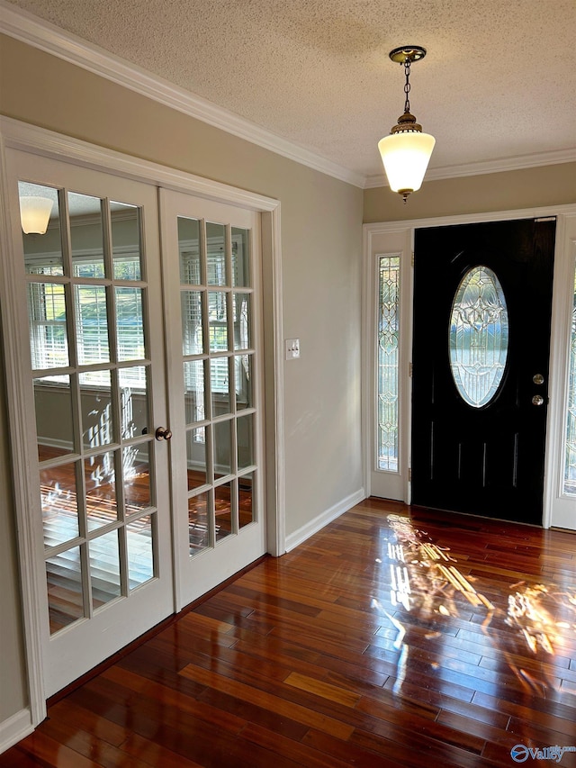 foyer entrance with ornamental molding, a textured ceiling, dark hardwood / wood-style flooring, and french doors