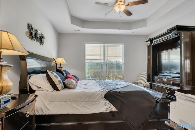 bedroom featuring ceiling fan and a tray ceiling