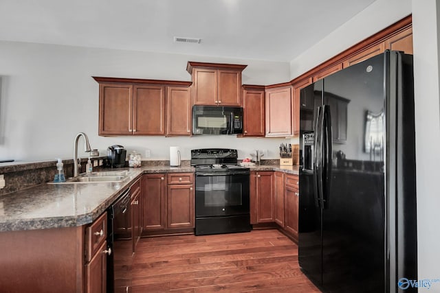 kitchen with dark hardwood / wood-style flooring, sink, black appliances, and kitchen peninsula