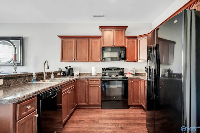 kitchen featuring light hardwood / wood-style floors, sink, and black appliances