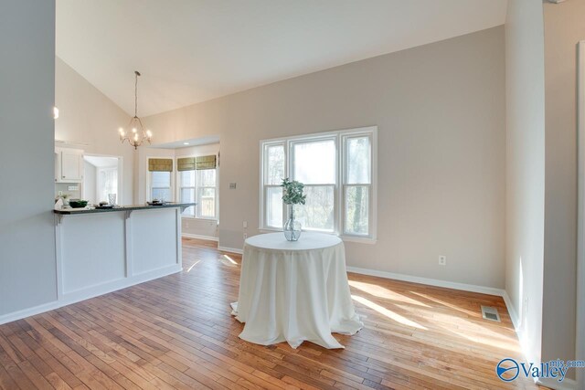 interior space with high vaulted ceiling, light hardwood / wood-style flooring, and an inviting chandelier