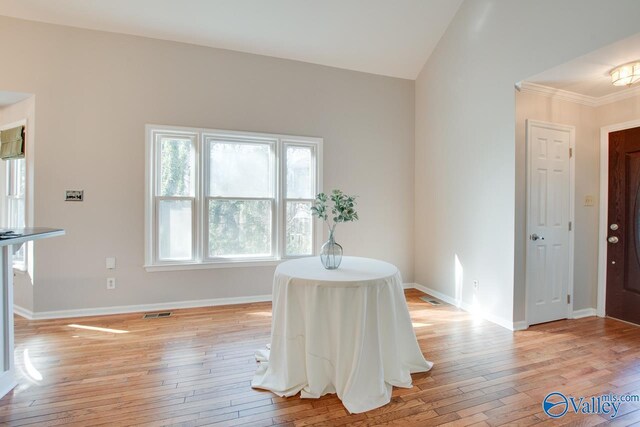 unfurnished dining area featuring light hardwood / wood-style floors and vaulted ceiling