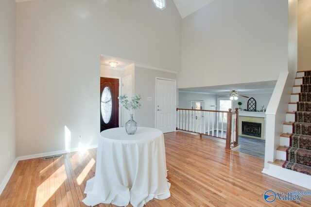 entryway featuring light wood-type flooring, high vaulted ceiling, and ceiling fan