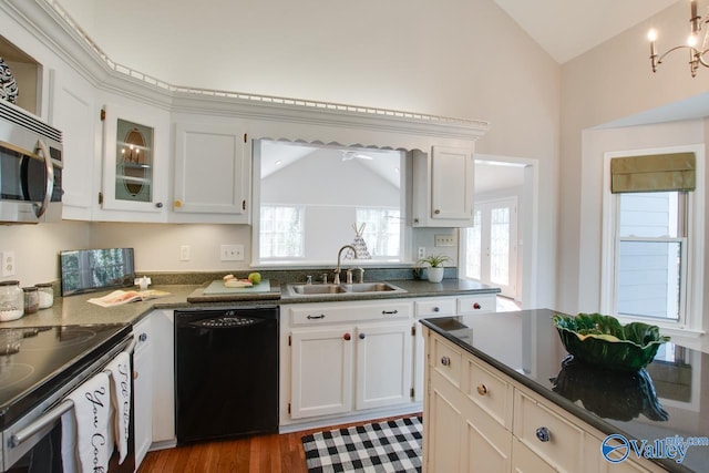 kitchen with vaulted ceiling, white cabinetry, sink, light hardwood / wood-style flooring, and stainless steel appliances