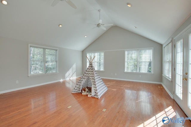 unfurnished living room with ceiling fan, light hardwood / wood-style flooring, and lofted ceiling