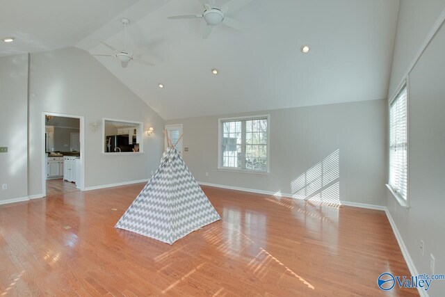 playroom with ceiling fan, light hardwood / wood-style flooring, and vaulted ceiling