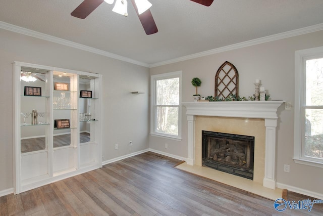 unfurnished living room featuring hardwood / wood-style flooring, ceiling fan, and ornamental molding