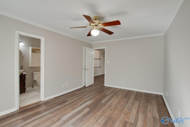 unfurnished bedroom featuring ceiling fan, hardwood / wood-style flooring, ornamental molding, and ensuite bath