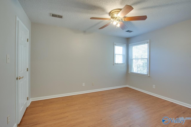 unfurnished room with ceiling fan, light hardwood / wood-style flooring, and a textured ceiling