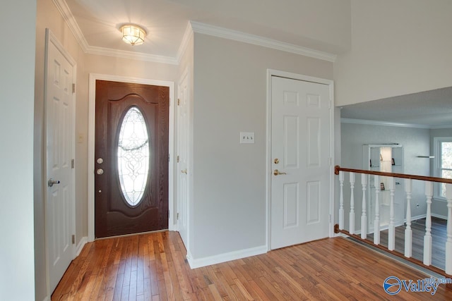 entryway with ornamental molding and wood-type flooring