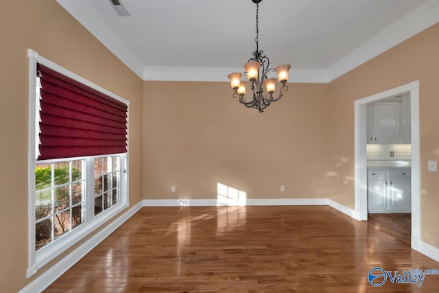 unfurnished dining area featuring dark hardwood / wood-style flooring, a chandelier, and ornamental molding