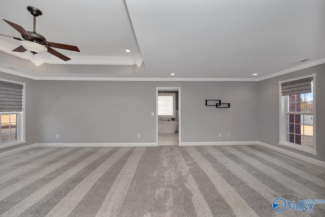 carpeted spare room with a wealth of natural light, crown molding, and ceiling fan