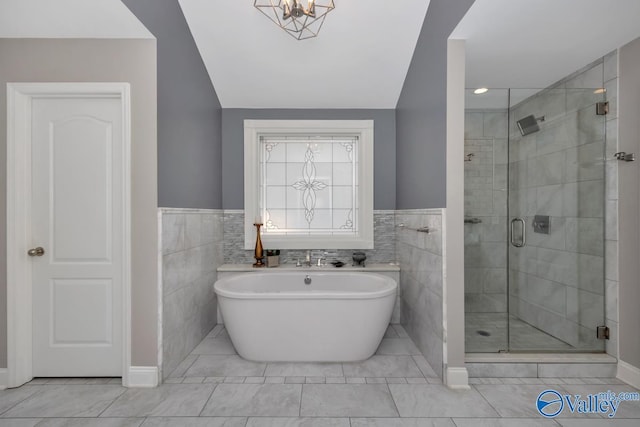 bathroom with tile walls, plus walk in shower, and vaulted ceiling