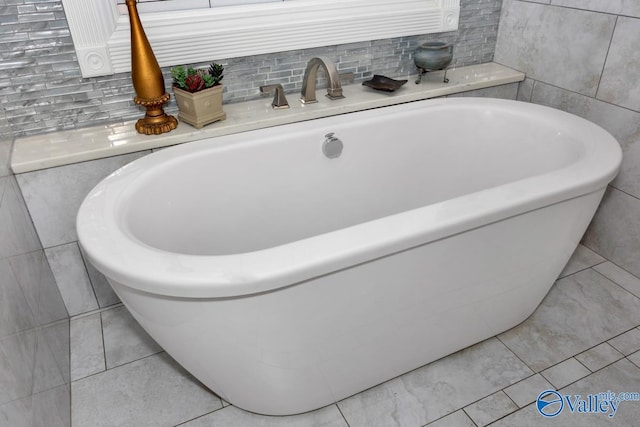 bathroom featuring a bath and tile walls