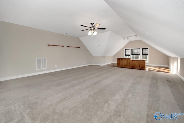 additional living space featuring ceiling fan, light colored carpet, and vaulted ceiling