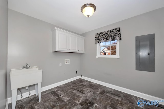 washroom with electric panel, hookup for a washing machine, and cabinets