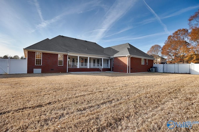 rear view of property with a yard and central AC unit