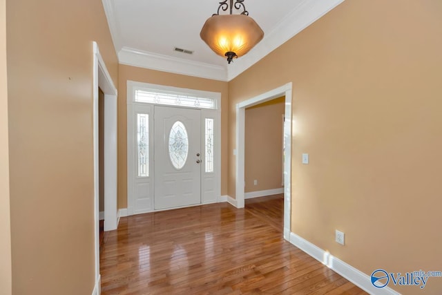 foyer entrance with crown molding and hardwood / wood-style floors