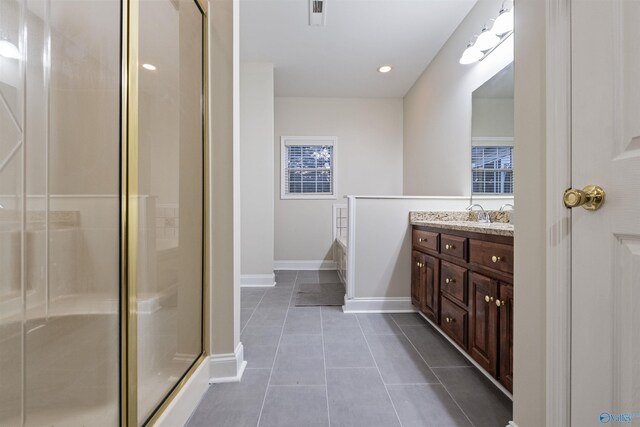 bathroom with tile patterned flooring, a shower with shower door, and vanity