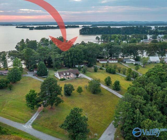 aerial view at dusk featuring a water view