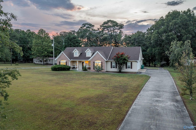 view of front of property with a porch and a lawn