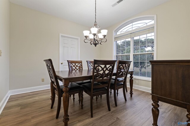 dining room with dark hardwood / wood-style floors and a chandelier