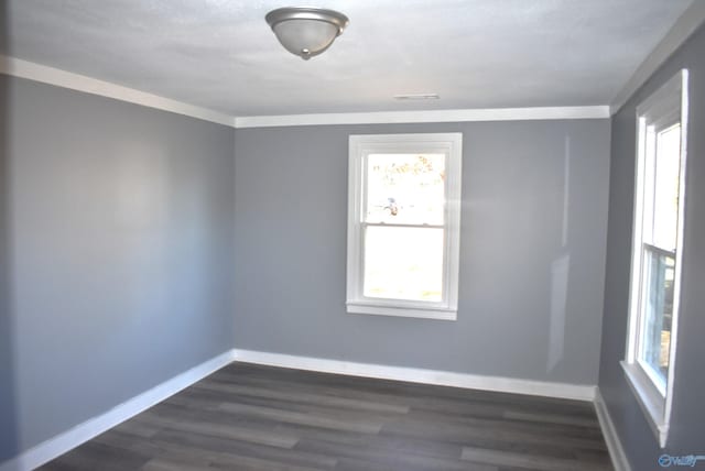 unfurnished room featuring crown molding, dark wood-type flooring, and a wealth of natural light