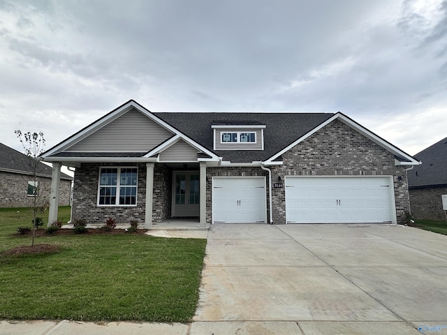 craftsman house with a front lawn and a garage