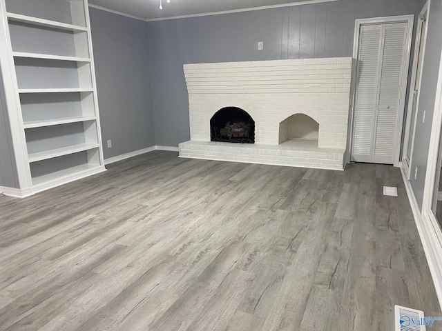 unfurnished living room with ornamental molding, hardwood / wood-style floors, and a fireplace