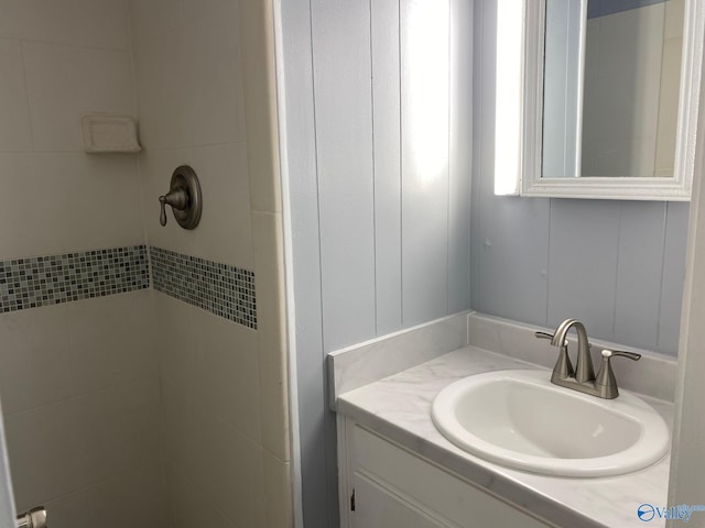 bathroom with vanity and a tile shower