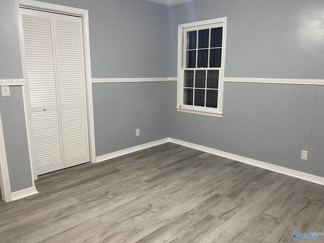 unfurnished bedroom with a closet and hardwood / wood-style floors