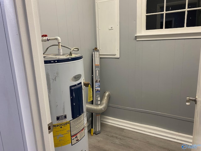 utility room featuring electric panel and water heater