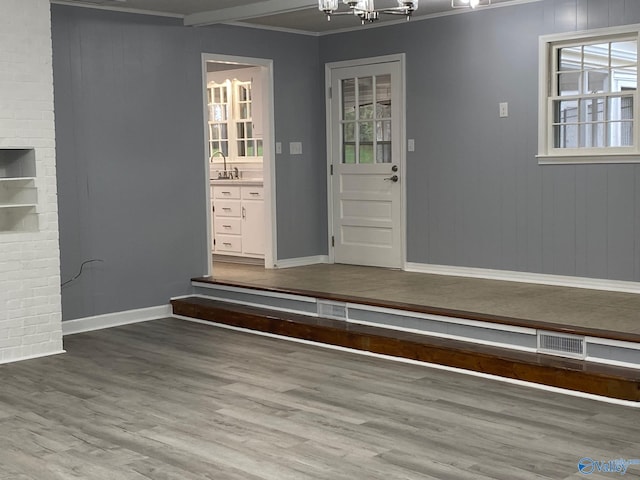 mudroom featuring wood-type flooring, a notable chandelier, sink, crown molding, and beam ceiling