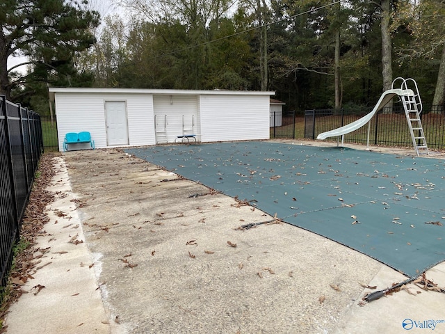 view of swimming pool with a water slide and a patio area