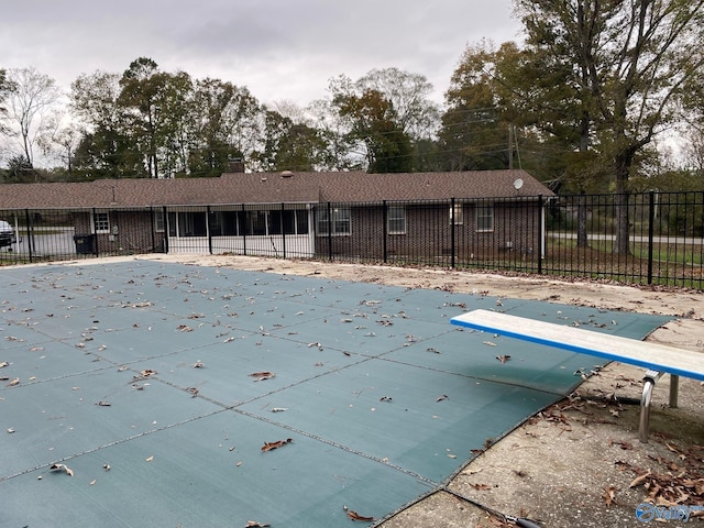 view of swimming pool with a diving board