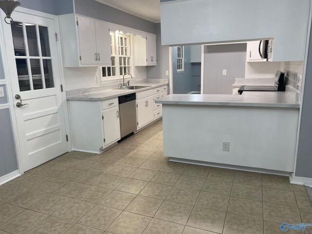 kitchen featuring sink, appliances with stainless steel finishes, light tile patterned floors, white cabinets, and decorative backsplash