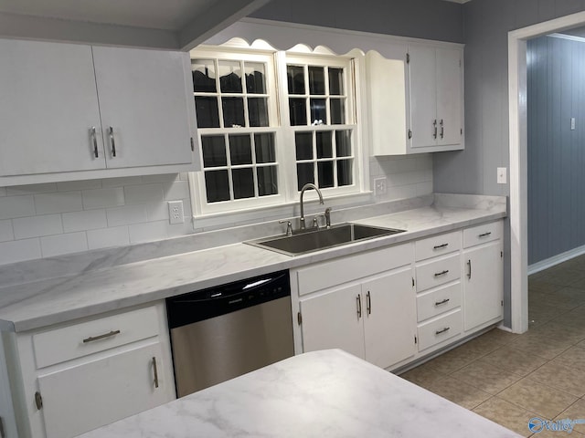 kitchen with decorative backsplash, stainless steel dishwasher, sink, and white cabinets