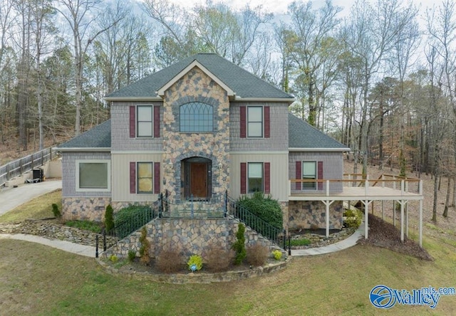 view of front of house with a wooden deck and a front lawn