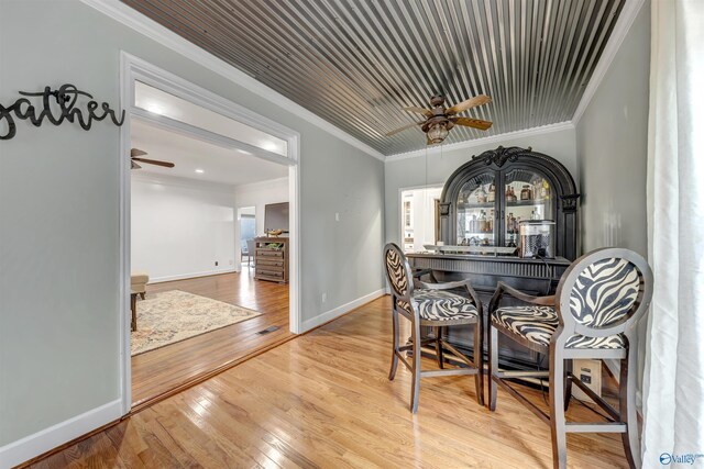 dining room with hardwood / wood-style flooring, crown molding, and ceiling fan