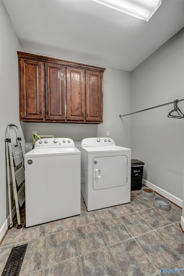 washroom with cabinets and washing machine and clothes dryer