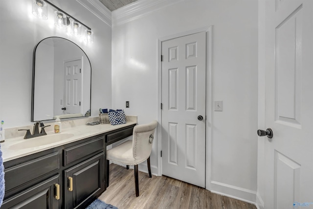 bathroom with crown molding, vanity, and hardwood / wood-style floors