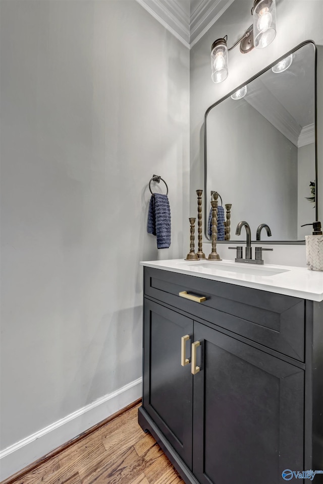 bathroom with crown molding, vanity, and hardwood / wood-style floors