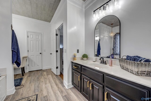 bathroom with ornamental molding, hardwood / wood-style floors, and vanity