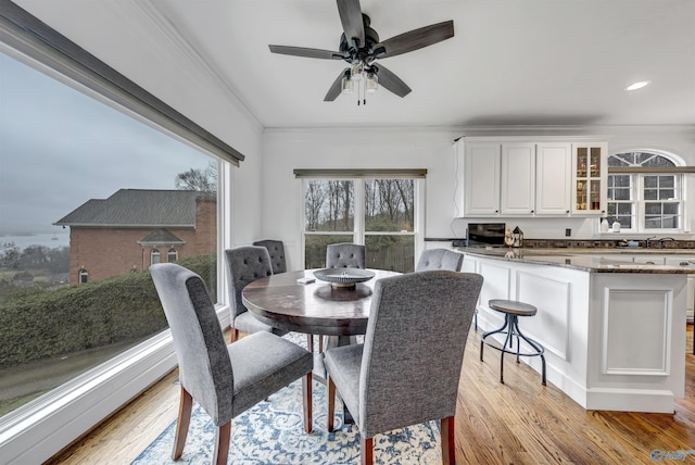 dining space featuring crown molding and light hardwood / wood-style flooring